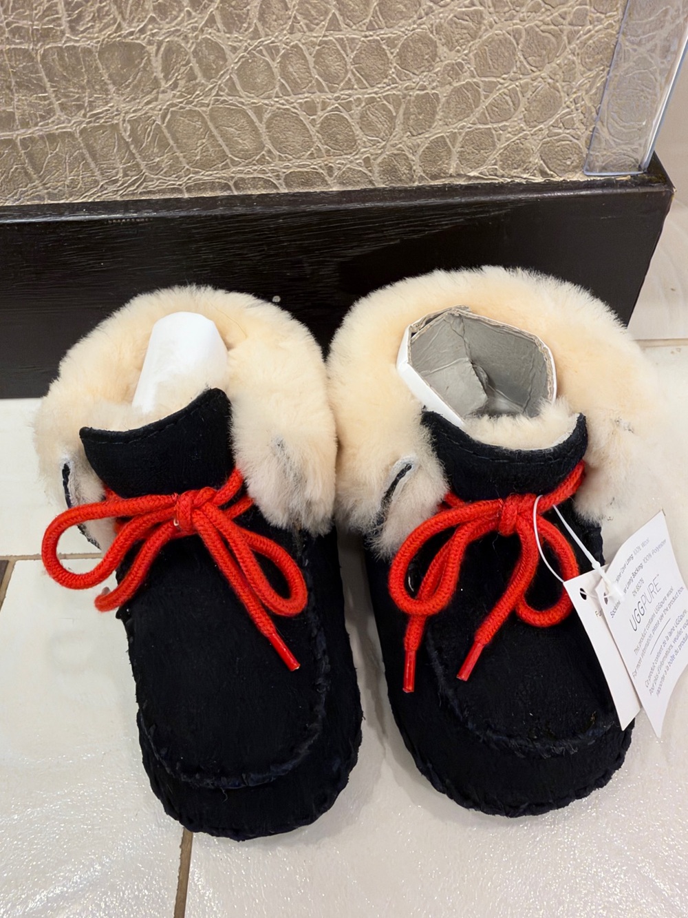 UGG Kids Black Moccasin Slippers with Cream Fur Cuff and Red Laces 2/3